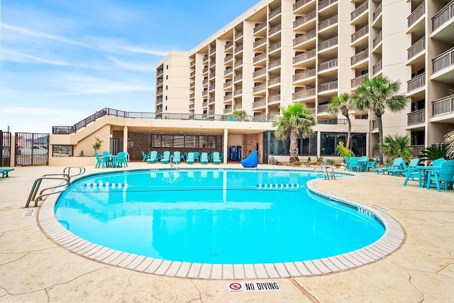 pool featuring fence and a patio area
