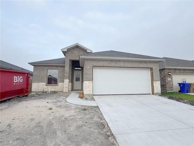 view of front facade featuring a garage, driveway, and brick siding