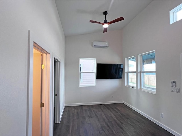 interior space featuring a wall unit AC, a wealth of natural light, dark wood-type flooring, and ceiling fan