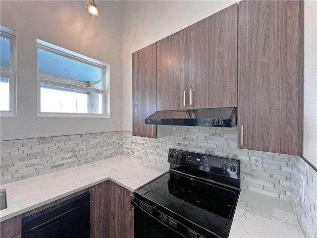 kitchen with light stone countertops, backsplash, and black appliances