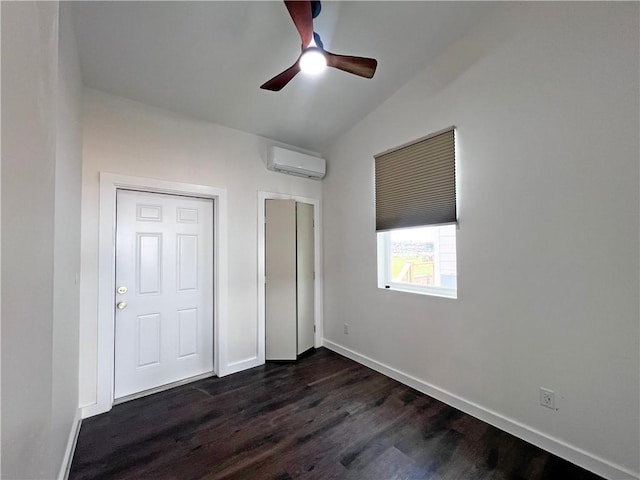 unfurnished bedroom featuring dark hardwood / wood-style flooring, vaulted ceiling, a wall mounted AC, and ceiling fan