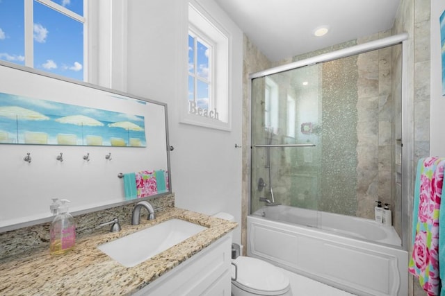 full bath featuring bath / shower combo with glass door, vanity, and toilet