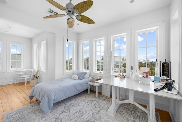 bedroom with multiple windows, visible vents, and hardwood / wood-style flooring