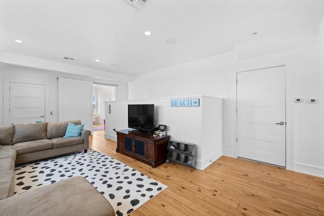 living area with light wood-type flooring, baseboards, visible vents, and recessed lighting