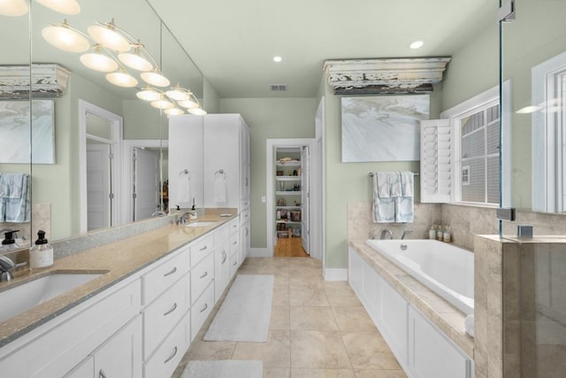 bathroom with a garden tub, tile patterned flooring, a sink, visible vents, and double vanity