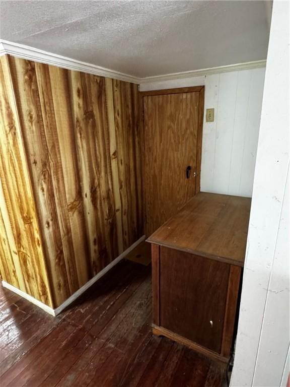 interior space featuring hardwood / wood-style floors, wood walls, and a textured ceiling