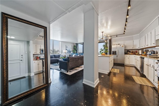 kitchen featuring rail lighting, light countertops, baseboards, white cabinets, and stainless steel appliances