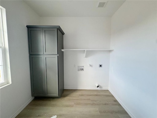 laundry room with cabinets, hookup for a washing machine, light wood-type flooring, and electric dryer hookup