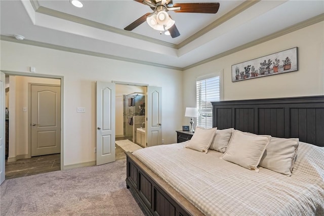 bedroom featuring a tray ceiling, connected bathroom, ceiling fan, and light colored carpet