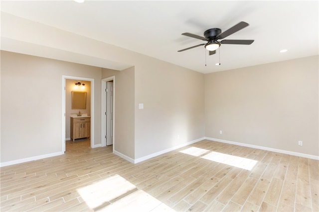 spare room featuring light wood-type flooring, ceiling fan, and sink