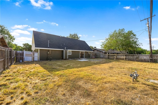 back of house with a lawn and a patio