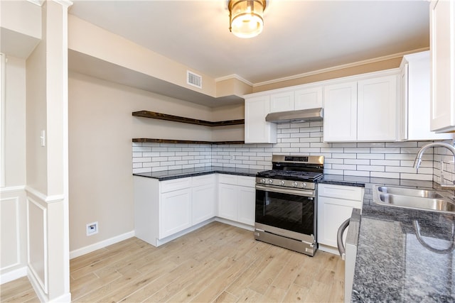 kitchen with stainless steel range with gas cooktop, white cabinets, sink, and light hardwood / wood-style flooring