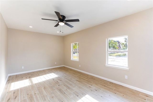 spare room with ceiling fan, plenty of natural light, and light hardwood / wood-style flooring