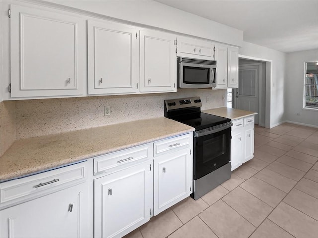 3658 Braeburn Dr, Corpus Christi, TX 78415 - kitchen with light tile patterned flooring, white cabinets, light stone countertops, baseboards, and appliances with stainless steel finishes