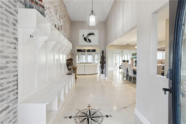 mudroom featuring finished concrete flooring and a high ceiling