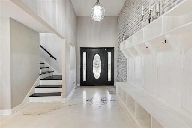mudroom featuring a towering ceiling and baseboards