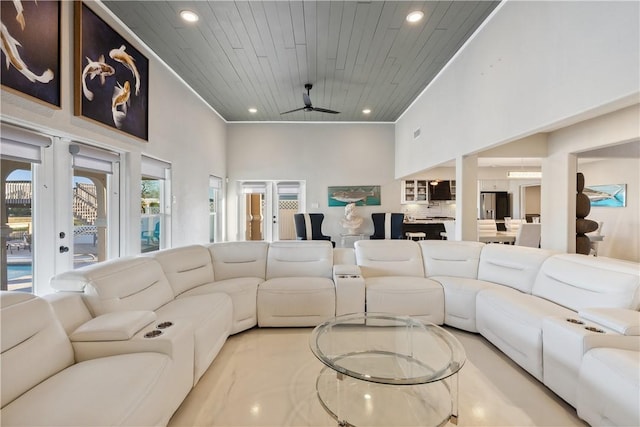 living area with wood ceiling, a high ceiling, a ceiling fan, and recessed lighting