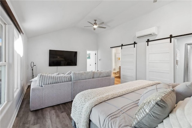 bedroom with baseboards, a barn door, an AC wall unit, wood finished floors, and lofted ceiling