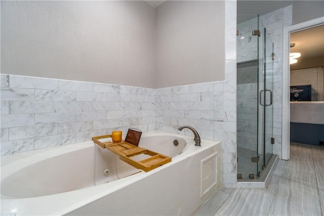 bathroom with a stall shower and a garden tub