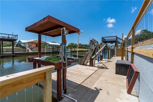 dock area with a water view and boat lift