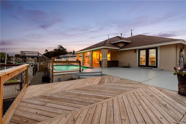 wooden deck featuring a patio, french doors, a jacuzzi, and a fenced in pool