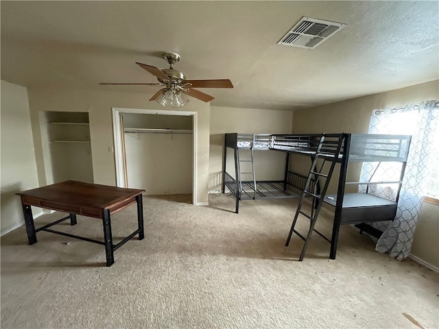 carpeted bedroom with ceiling fan and a closet