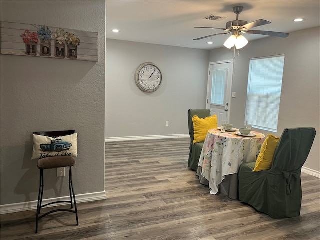 living area featuring hardwood / wood-style flooring and ceiling fan