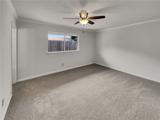 spare room featuring a ceiling fan, baseboards, crown molding, and carpet flooring