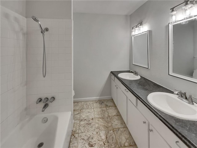 full bathroom with double vanity, shower / tub combination, baseboards, and a sink