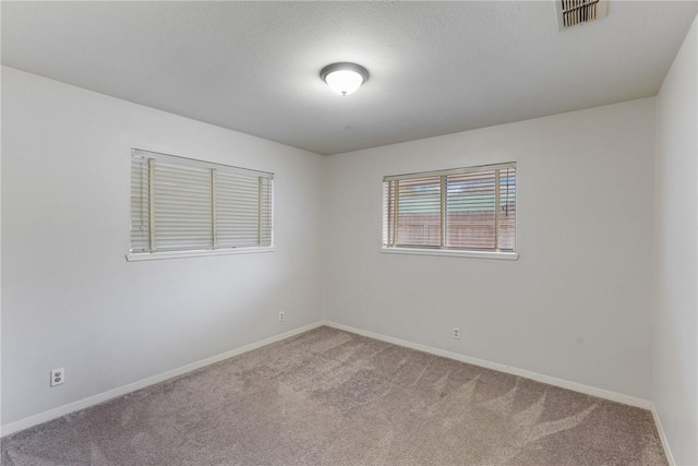 empty room with a textured ceiling and carpet flooring