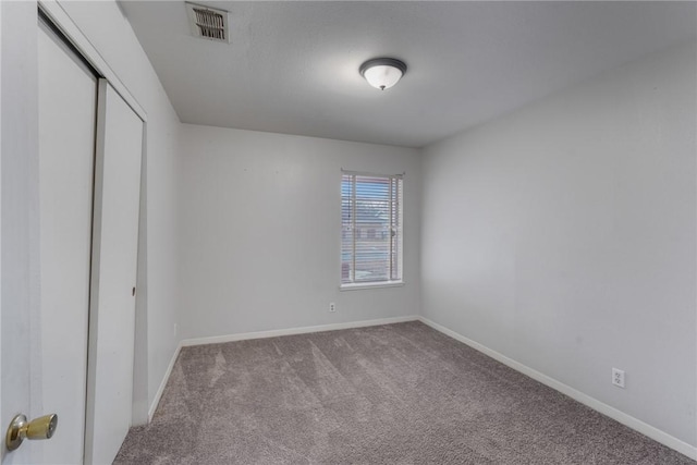 unfurnished bedroom with light colored carpet and a closet