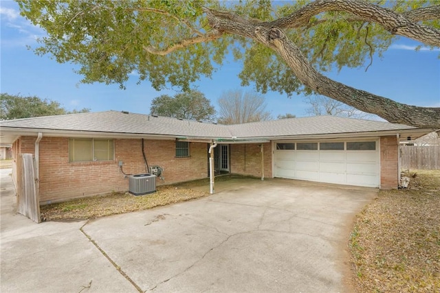 single story home featuring cooling unit and a garage