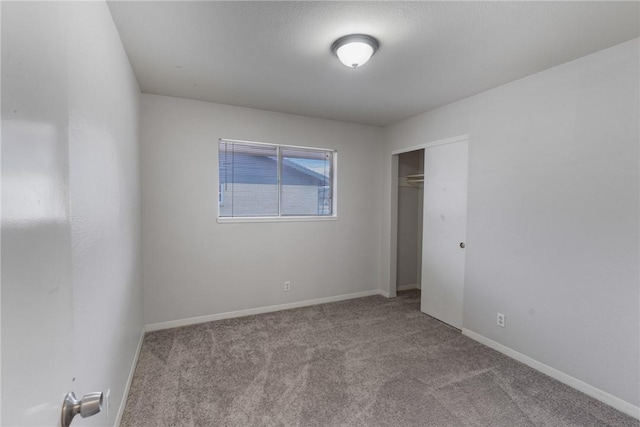 unfurnished bedroom with a closet and light carpet