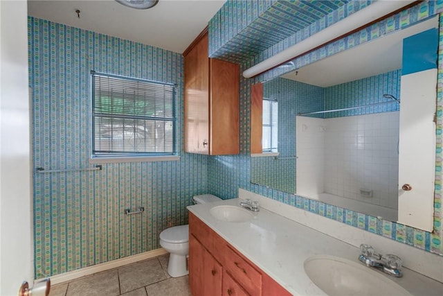 full bathroom featuring tile patterned flooring, vanity, tiled shower / bath, and toilet