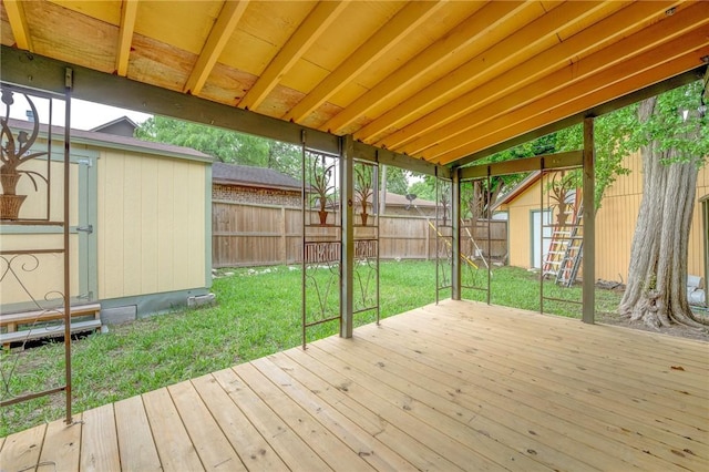 wooden deck with a fenced backyard, a shed, an outbuilding, and a yard