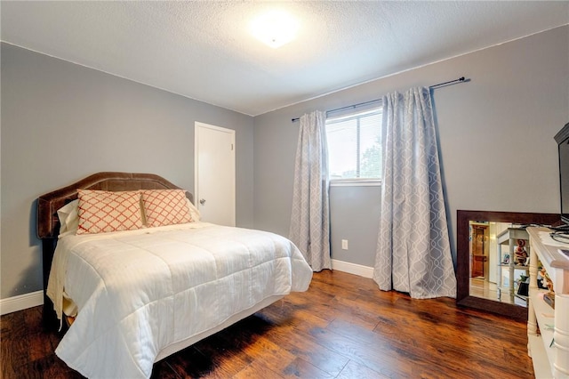 bedroom with baseboards and wood finished floors
