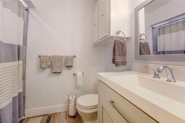 full bath with wood finished floors, a shower with shower curtain, toilet, vanity, and baseboards