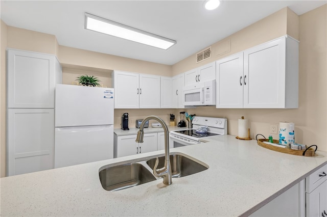 kitchen with white cabinetry, light stone counters, sink, and white appliances