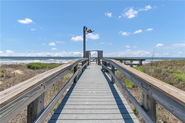 view of dock featuring a water view and a view of the beach