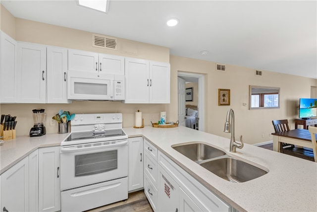 kitchen with light stone counters, sink, white cabinetry, light hardwood / wood-style flooring, and white appliances