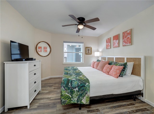 bedroom with dark hardwood / wood-style flooring and ceiling fan