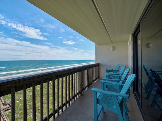 balcony with a water view and a view of the beach