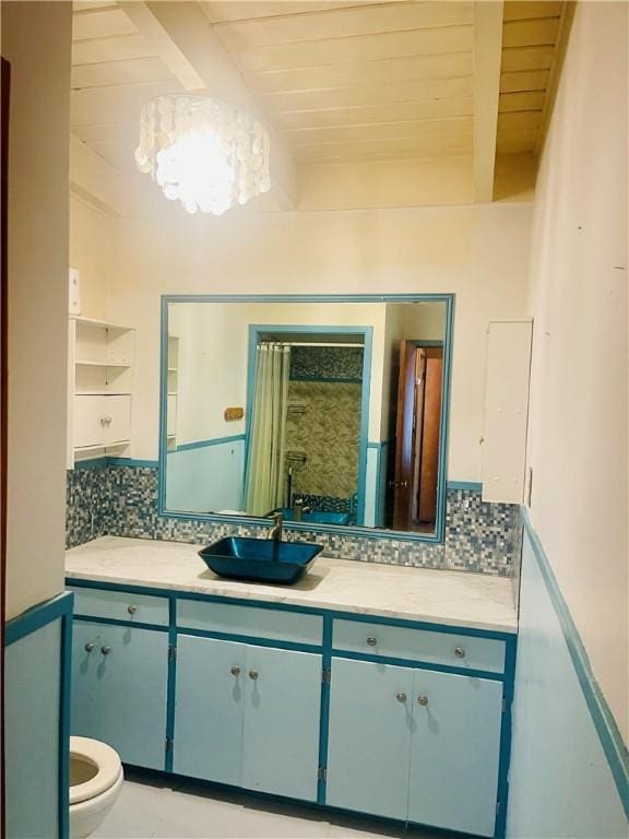 bathroom featuring wooden ceiling, toilet, vanity, tasteful backsplash, and beamed ceiling