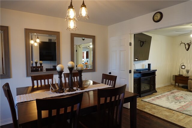 dining area with dark hardwood / wood-style floors and ceiling fan with notable chandelier