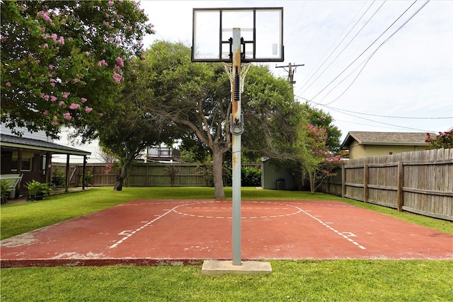 view of sport court with a lawn