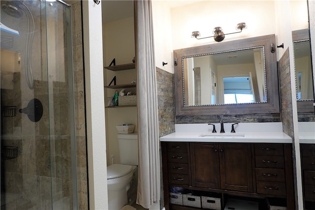 bathroom featuring toilet, vanity, and walk in shower