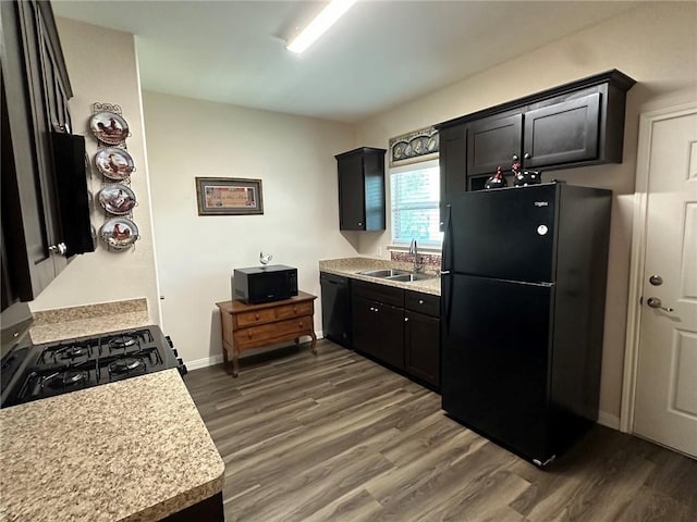 803 Molina St, Robstown, TX 78380 - kitchen featuring black appliances, a sink, dark wood finished floors, light countertops, and baseboards