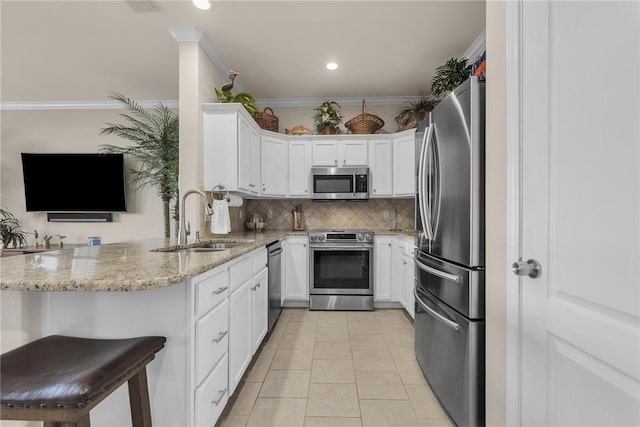 14901 Windward Dr Unit 704, Corpus Christi, TX 78418 - kitchen with a sink, decorative backsplash, light stone counters, white cabinetry, and appliances with stainless steel finishes