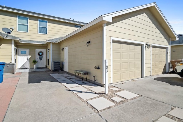 view of side of property with cooling unit and a garage