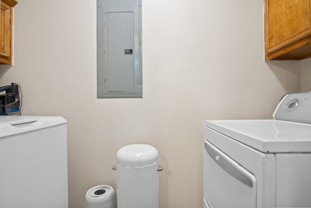 laundry area with electric panel, cabinets, and washing machine and dryer